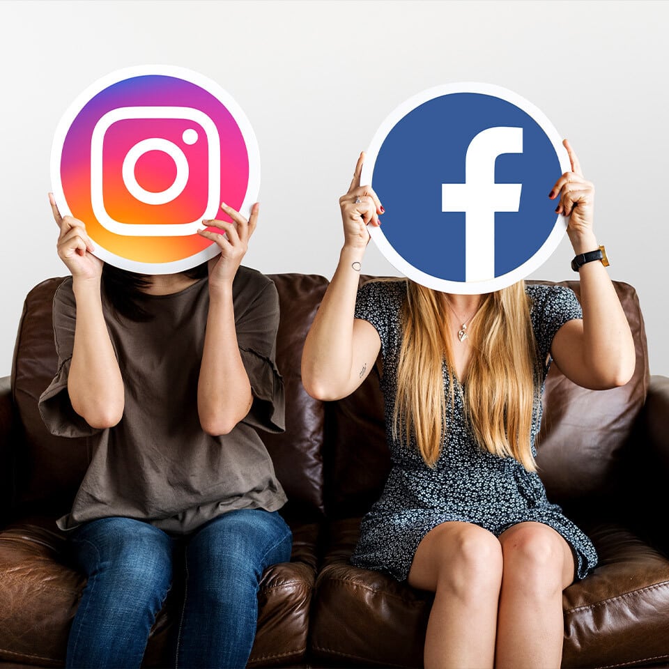 To personer holder store cirkler med Instagram og Facebook logoer foran deres ansigt.